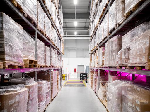 Sector ampliado de la planta con estanterías altas y paquetes de carpetas listas para despacho